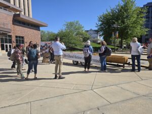 people gather around a dugout canoe