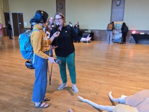 Bonnie Willison and Jennifer Hauxwell speak to each other next to a giant stuffed beetle