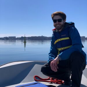 Researcher on the prow of a boat floating on a Wisconsin lake.