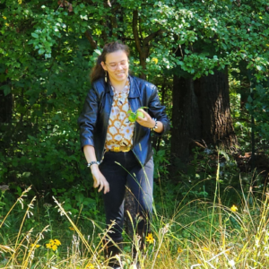 Researcher walking through a field at the edge of the forest