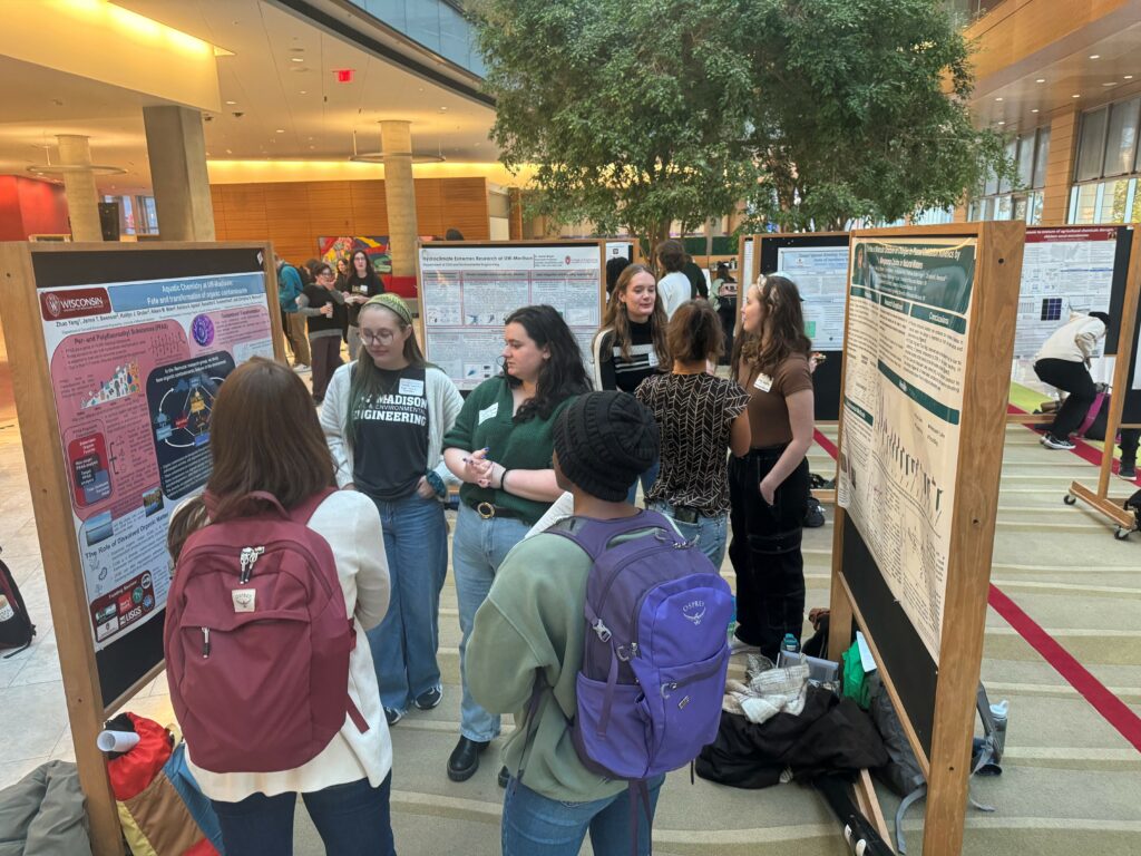 Attendees network and chat about water research at an art and science poster session.