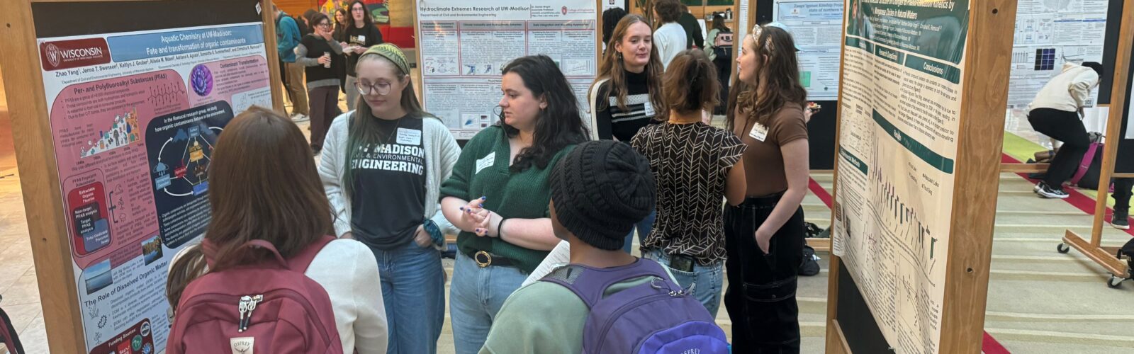 Attendees network and chat about water research at an art and science poster session.