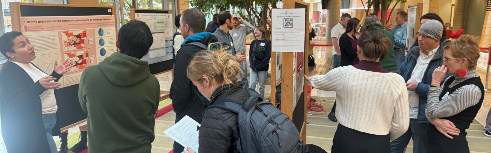 Attendees network and chat about water research at an art and science poster session.