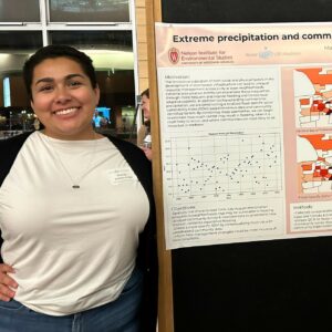 Researcher standing next to a poster about flood vulnerability in Madison, WI