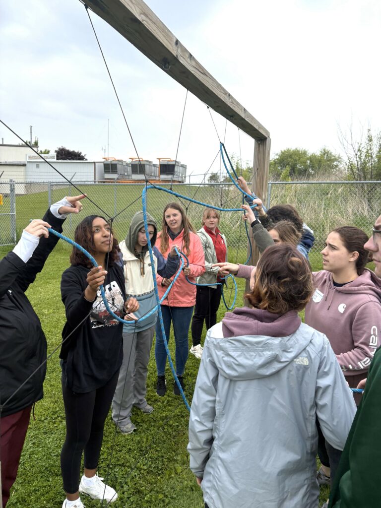 Students puzzle through a low ropes course