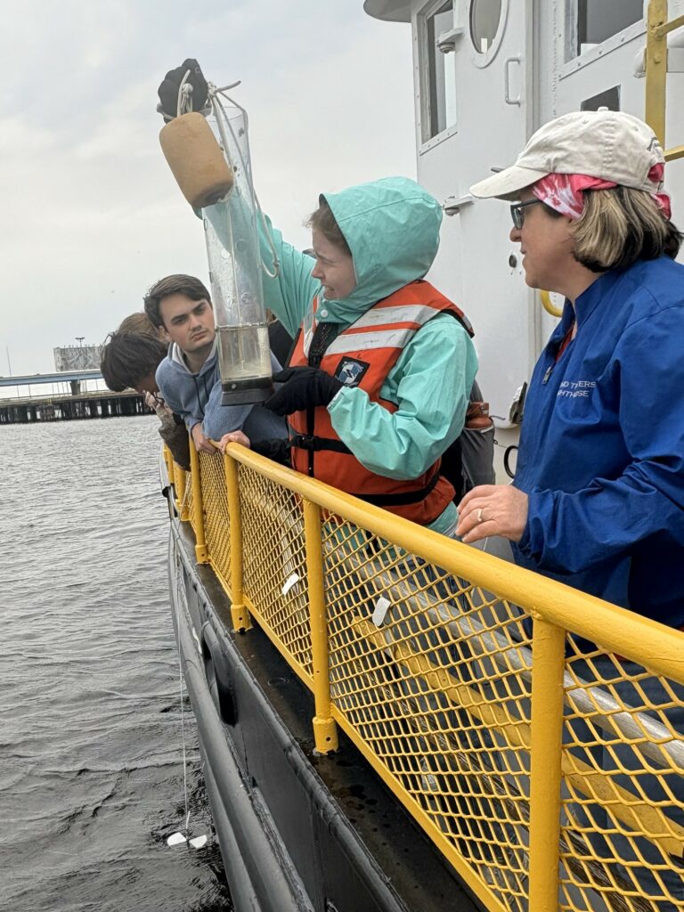 Student reads temperature from a surface sample onboard the Neeskay in Lake Michigan