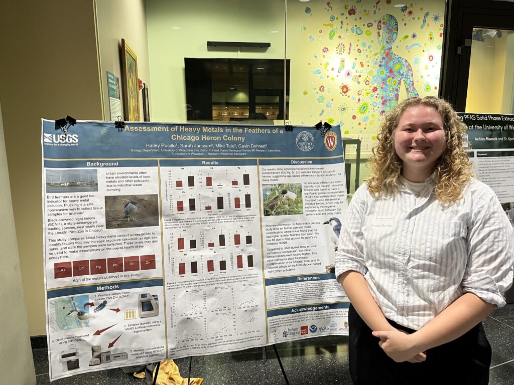 Research stands next to her poster