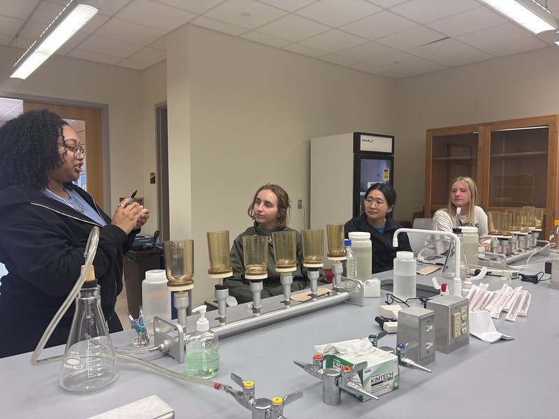 Students receive instruction on how to filter water samples in a lab.
