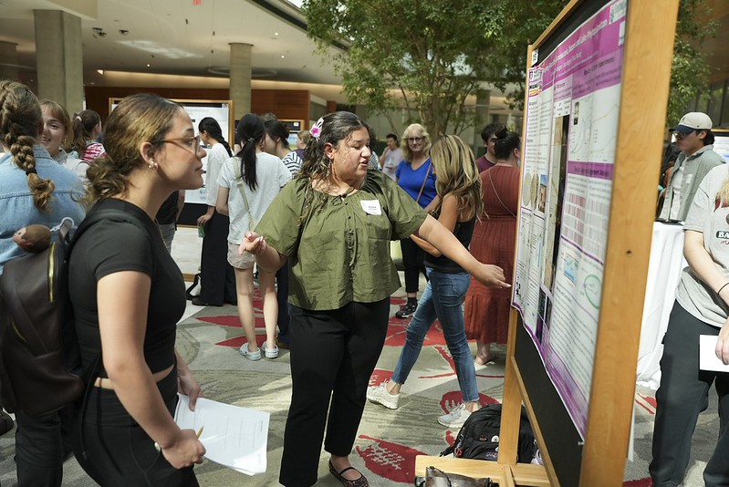 Student presents a scientific poster to attendees